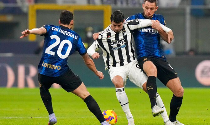 Alvaro Morata de Juventus disputa el balon con Calhanoglu del Inter
