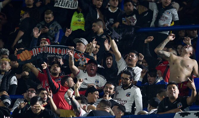 Hinchas de Colo Colo alientan al equipo albo en las tribunas de La Bombonera